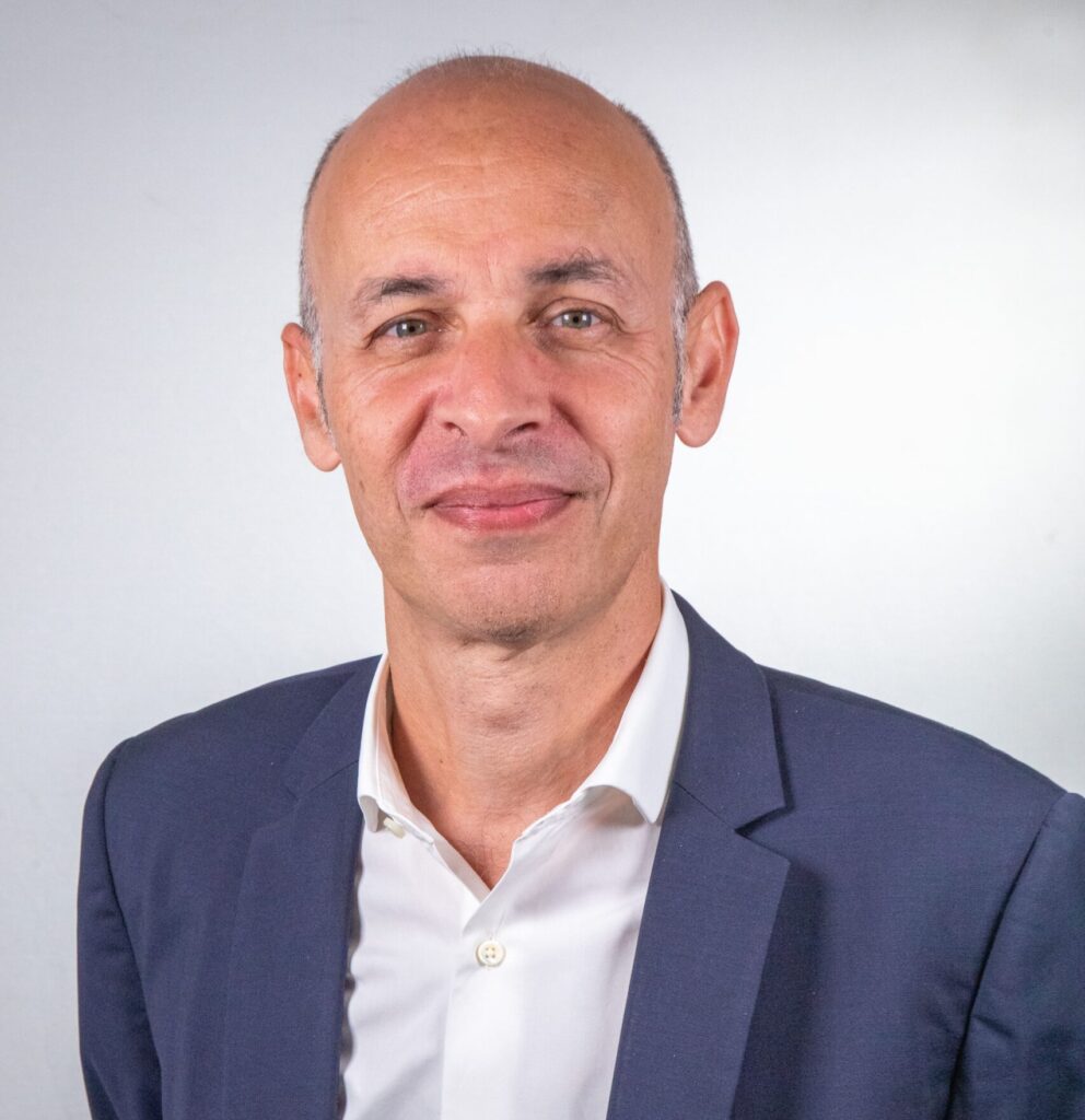 Portrait de Jean-David Cohen, DSI du Groupe ENSIO, en veste bleu marine sur fond gris